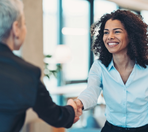 Photo of a woman shaking hands on her client